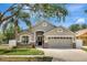 Charming single-story home with a well-manicured lawn and neutral gray and stone exterior at 11209 Taeda Dr, Orlando, FL 32832