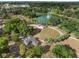 Beautiful aerial view of a park with a pond, fountain, stage, walking paths, and lush greenery in a tranquil setting at 116 Hurst Ct, Deland, FL 32724