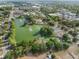 Picturesque aerial view of a park with a pond, fountains, lush greenery, and walking paths in a tranquil setting at 116 Hurst Ct, Deland, FL 32724