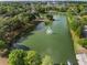 Scenic aerial view of a serene lake featuring a fountain, lush green surroundings, and clear blue skies at 116 Hurst Ct, Deland, FL 32724