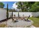 Gravel fire pit area with four chairs, mature landscaping, and a privacy fence at 116 Hurst Ct, Deland, FL 32724