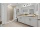 Well-lit bathroom featuring dual sinks, neutral tiled shower, and ample cabinet space at 116 Hurst Ct, Deland, FL 32724