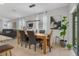 Open-concept dining area boasts a modern light fixture, sleek furniture, and scenic backyard views at 116 Hurst Ct, Deland, FL 32724