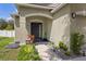 Welcoming front entrance with a stylish black door, elegant tiled steps, and manicured landscaping at 116 Hurst Ct, Deland, FL 32724