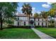 Exterior of a grand two-story home with a manicured lawn, mature trees, and a inviting walkway to the entrance at 116 Hurst Ct, Deland, FL 32724