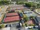 Aerial view of multiple tennis courts and pickleball courts alongside covered seating areas and parking at 116 Hurst Ct, Deland, FL 32724