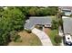 Aerial view of house with a well-maintained lawn, palm trees, and long driveway at 1209 Stevens Ave, Orlando, FL 32806
