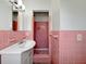 Bathroom featuring unique pink tiling, shower, and vanity with sink at 1209 Stevens Ave, Orlando, FL 32806