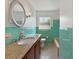 Bathroom with green tile, granite counters, bathtub, and updated fixtures at 1209 Stevens Ave, Orlando, FL 32806