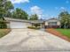 Charming single-story home featuring a well-manicured lawn and a spacious driveway leading to a two-car garage at 1209 Stevens Ave, Orlando, FL 32806