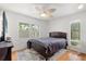 Bright bedroom with wood floors, ceiling fan, and large window overlooking the trees at 121 Teriwood St, Fern Park, FL 32730