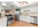 Bright kitchen featuring stainless steel appliances, tile countertops, and access to other areas of the house at 121 Teriwood St, Fern Park, FL 32730