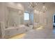 Bright, modern bathroom features double vanity, soaking tub and marble floors at 1220 Delaney Park Dr, Orlando, FL 32806