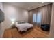 Bedroom with soft, neutral decor featuring a cozy bed, dark armchair, and a woven area rug at 1220 Delaney Park Dr, Orlando, FL 32806