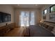 Neutral bedroom featuring a wooden console table, a leather bench, hardwood floors, and soft, sheer curtains at 1220 Delaney Park Dr, Orlando, FL 32806