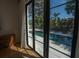 A bedroom view through large windows featuring a pristine swimming pool with ample lounge space at 1220 Delaney Park Dr, Orlando, FL 32806
