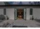 View of a modern outdoor patio with fire pit, chairs, and access to the dining room through glass doors at 1220 Delaney Park Dr, Orlando, FL 32806