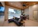 Open concept living area featuring a modern sofa, tile floors, wood ceiling and an outdoor kitchen and pool view at 1220 Delaney Park Dr, Orlando, FL 32806