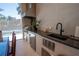 Covered outdoor kitchen featuring stainless steel appliances, a built-in grill, a dining area, and backyard views at 1220 Delaney Park Dr, Orlando, FL 32806