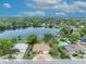 Aerial view showcasing the house, community with private pools, serene lakefront and lush greenery at 1329 Maury Rd, Orlando, FL 32804