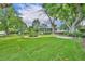 Spacious lawn with shade trees, stone table and access to a screened in porch at 1329 Maury Rd, Orlando, FL 32804