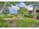 Serene backyard featuring a brick patio with stone table, lush landscaping, and a peaceful lake view at 1329 Maury Rd, Orlando, FL 32804