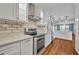 Bright kitchen featuring stainless steel appliances, white cabinetry, and subway tile backsplash at 1329 Maury Rd, Orlando, FL 32804