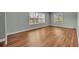 Open living room with hardwood floors, neutral paint, and ample natural light from bright windows at 1329 Maury Rd, Orlando, FL 32804