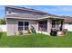 A charming backyard features green grass, a screened in porch and a barbecue grill on the patio at 1423 Marsh Meadow Ln, Davenport, FL 33896