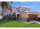 Charming two-story home featuring a stone-accented entrance and a well-maintained lawn at 1423 Marsh Meadow Ln, Davenport, FL 33896
