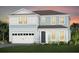 Charming two-story home with a white garage door, manicured lawn and colorful plants at 15319 Soaring Bluff Dr, Montverde, FL 34756