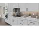 Close up of a kitchen featuring white cabinets, modern appliances, and a gray backsplash at 15319 Soaring Bluff Dr, Montverde, FL 34756