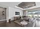 Comfortable living room featuring a tray ceiling, shiplap wall, and a large window at 15319 Soaring Bluff Dr, Montverde, FL 34756