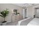 Well-lit main bedroom featuring a large mirror, dresser, and a view into the ensuite at 15319 Soaring Bluff Dr, Montverde, FL 34756