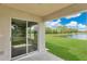 Covered back porch with sliding glass doors overlooking a lush lawn and serene pond at 1556 Sherbourne St, Winter Garden, FL 34787