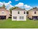View of the backyard featuring lush green lawn and a simple two-story home at 1556 Sherbourne St, Winter Garden, FL 34787