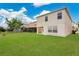 Expansive backyard with lush lawn, view of a two-story home, and verdant landscaping at 1556 Sherbourne St, Winter Garden, FL 34787