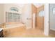 Well-lit bathroom with a soaking tub under a window, plus a glass block shower at 1709 Iverness Ct, Longwood, FL 32779