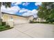 Home with a wide driveway and a three-car garage under a sunny, partly cloudy sky at 1709 Iverness Ct, Longwood, FL 32779