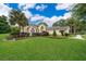 Charming single-story home with a manicured lawn, tasteful landscaping, and mature palm trees enhancing the curb appeal at 1709 Iverness Ct, Longwood, FL 32779