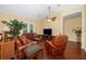 Cozy living room with hardwood floors, a ceiling fan, and a comfortable leather sofa at 1709 Iverness Ct, Longwood, FL 32779