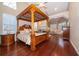 Elegant main bedroom with a four-poster bed, hardwood floors, and a cozy seating area at 1709 Iverness Ct, Longwood, FL 32779