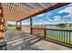 Beautiful back patio with pergola, a lake view, and a wooden railing around the edge at 1712 Boat Launch Rd, Kissimmee, FL 34746
