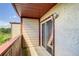 A covered balcony with railing, sliding glass door, and an outdoor light fixture at 1826 Warringwood Dr # B-1, Orlando, FL 32839