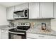 Kitchen featuring stainless steel microwave and range with granite countertops at 1826 Warringwood Dr # B-1, Orlando, FL 32839