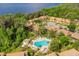 An aerial view of community buildings and a pool surrounded by palm trees and mature trees at 190 Hickory Woods Ct # 12B, Deltona, FL 32725