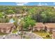 Aerial view of the community showcasing manicured landscaping, mature trees, and a sparkling swimming pool at 190 Hickory Woods Ct # 12B, Deltona, FL 32725