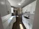 Open-concept kitchen featuring modern cabinetry, countertops, and stainless steel appliances, complemented by wood-look flooring at 1921 Nw 12Th St, Ocala, FL 34475