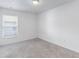 Inviting bedroom with neutral carpet, window overlooking the outdoors, and fresh white walls at 205 Lori Ct, Umatilla, FL 32784