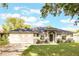 Charming single-story home featuring a well-manicured lawn, a two-car garage, and a welcoming front entrance at 205 Lori Ct, Umatilla, FL 32784